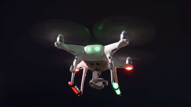 Drone hovering at night with strobes and glow sticks