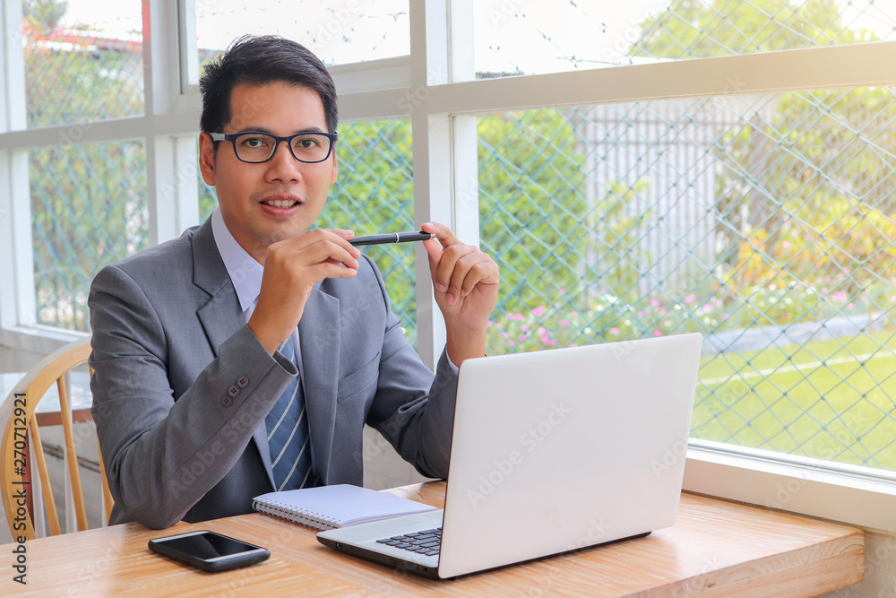 Wall mural business man working on laptop in office