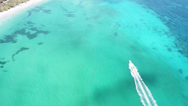 drone aerial over speed boat and light blue sea at  les salines beach table du diable savane des petrifications sainte anne martinique