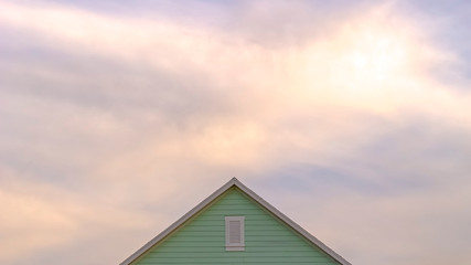 Panorama Top exterior of a house with view of the light green wall and gable vent