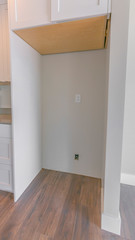 Vertical frame Interior of a kitchen with hanging cabinet above the empty refrigerator alcove