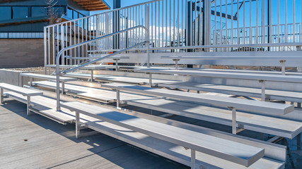 Panorama Bleachers with railings against a building and cloudy blue sky
