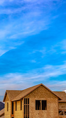 Vertical frame Exterior of a house under construction against vivid blue sky with clouds
