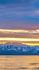 Vertical frame Panoramic view of a shiny lake and mountain covered with sharp white snow