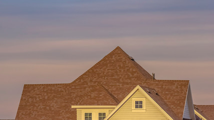 Panorama Family house with an off white wall that contrasts with the brown roof
