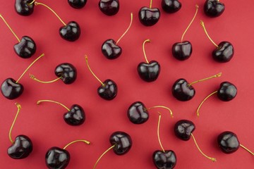 Naklejka na ściany i meble sweet cherry macro background. Red ripe sweet cherry close-up on a bright red background.Berry pattern. Sweet cherry season