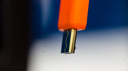 Orange colour usb cable in close up view.