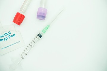 Blood taking kit, Empty syringe with needles, blood container tube and alcohol swab against isolated white background, medical concept
