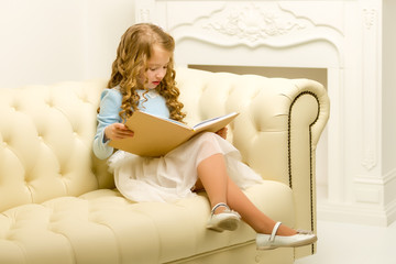 Little girl is sitting on the couch