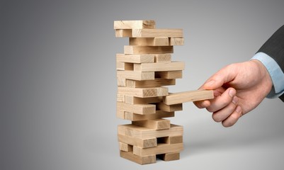 Wood blocks stack game with Hand on background,Conceptual of Teamwork, Strategy and Vision.