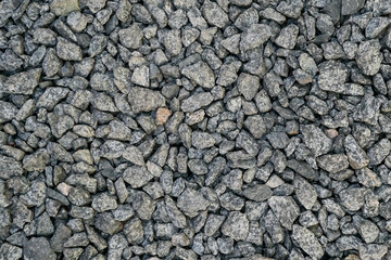 Crushed small pieces of stone closeup background. Gravel is used in construction.