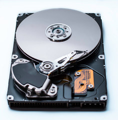 Close up of a Disassembled computer hard drive on white isolated background with reflection