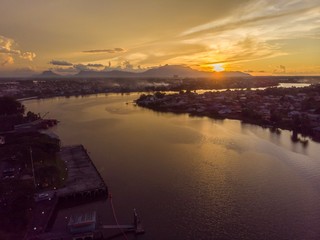 scenic aerial view of Sarawak River during sunset with Gunung (mountain) Serapi at the background © MuhammadFadhli