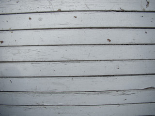 Fototapeta na wymiar Background of old boards. White paint coating. Peeling, defects.