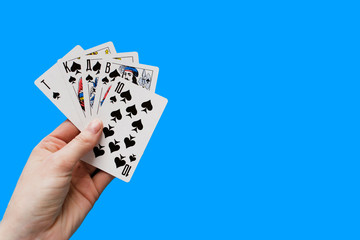 Playing card. Hand with card playing poker .close up of male hand with playing cards and chips at home. Pocker game. Casino cards as background. Concept for games, gambling in casino and sports poker.