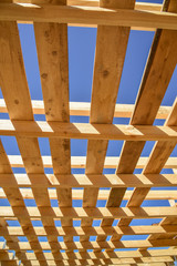 Wood frame residential building under construction.Building construction, wood framing structure at new property development site.new home currently under construction against blue sky.mortgage, loan.