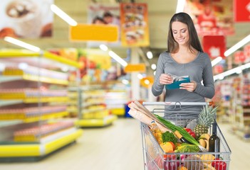 Woman with cart shopping in supermarket