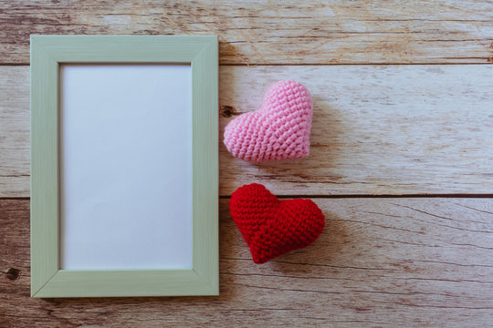 Retro style pastel green frame with pink and red hearts on wooden white floor