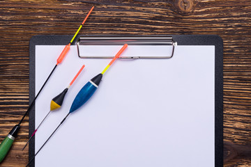 On the tablet with a clean sheet are different floats for a fishing rod, a place for your inscription