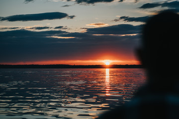 Weathered Man looking Towards a Sunset on a Sailboat