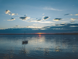 Sailboat Anchored on the Water during Sunset
