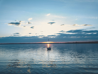 Sailboat Anchored on the Water during Sunset