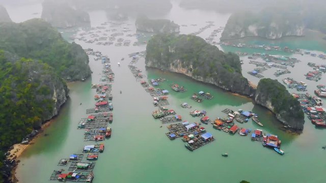 Aerial view of floating villages around Cat Ba islands. Cat Ba is the largest of the 366 islands, which make up the southeastern edge of Ha Long Bay in Vietnam. 4K move drone