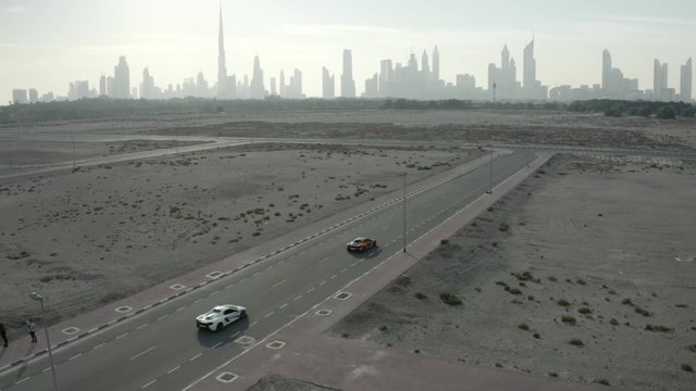aerial of supercars on empty road on the outskirts of dubai