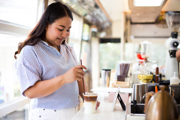 Woman holding plastic glass of iced coffee with milk on cafe background, Selective Focus.