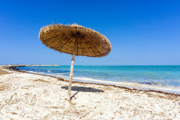 Beach with umbrella on the Mediterranean Sea in Djerba, Tunisia