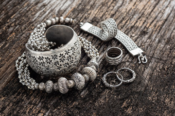 Collection of antique traditional silver jewelry on old wood