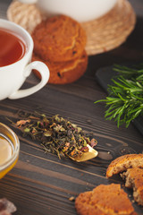 glass teapot with cup of black tea on wooden table