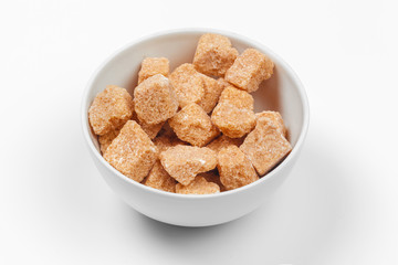 Brown cane sugar cubes isolated on white background