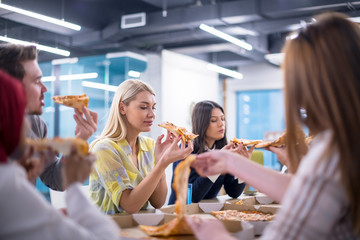 multiethnic business team eating pizza