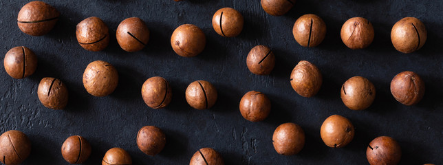 Top view of background texture of fresh natural unshelled raw macadamia nuts, full frame and flat...