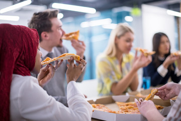 multiethnic business team eating pizza