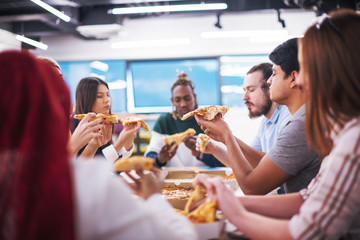 multiethnic business team eating pizza