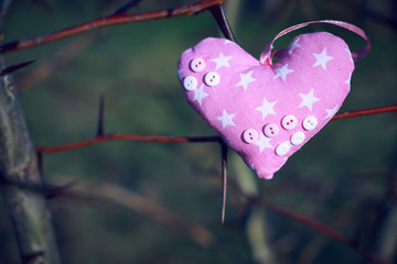 An image of a soft toy in the shape of a heart. Handicraft work.