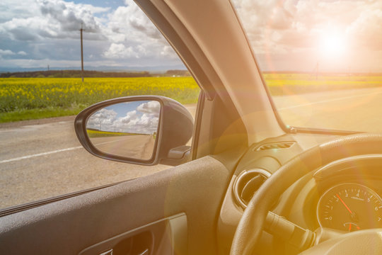 Car trip. Road view reflection on side mirror. Sunshine toned photo