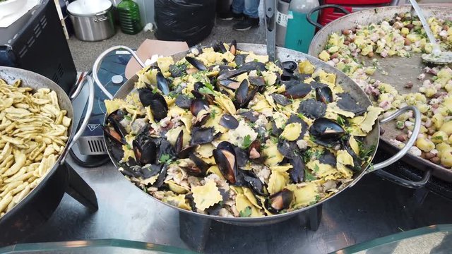Italian street food with traditional Sicilian gastronomy of  various types of pasta with seafood and regional products