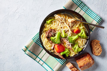 close-up of chicken noodle soup with broccoli