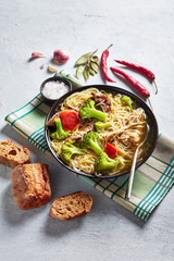 chicken noodle soup with broccoli in a bowl