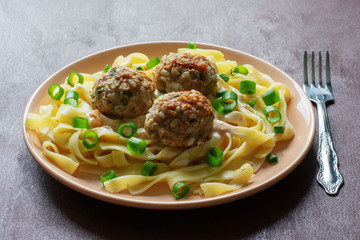 Pasta with meatballs on a dark background
