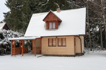 Wooden cottage in forest in winter -  accommodation for winter holiday