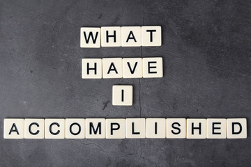 Obraz premium What have I accomplished motivational phrase formed with tile letters 