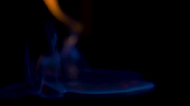 SLOW-MO CLOSE UP, OF NOEN BLUE FIRE  alcohol fire spreads and comes directly for the camera, flames look as if they are touching the camera