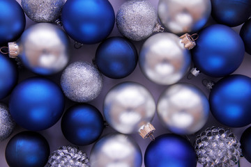 Christmas balls in blue and white colors close up on lilac background