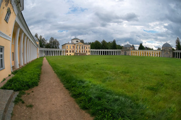 Obraz premium Architectural ensemble Manor Znamenskoye-Rayok. The manor house and the circular colonnade connecting it with the side wings (carriage and greenhouse) and the main gate opposite to it.