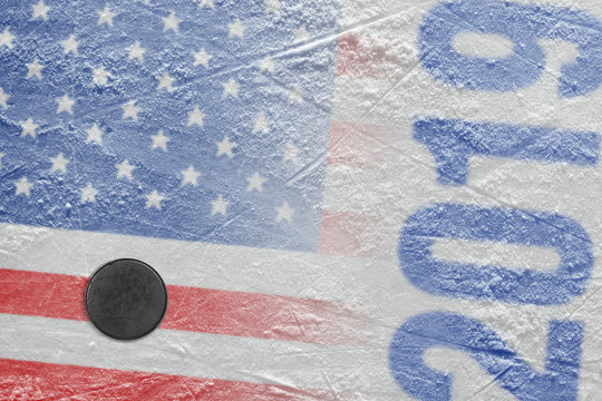 Hockey puck lying on the ice of the arena with the image of the American flag