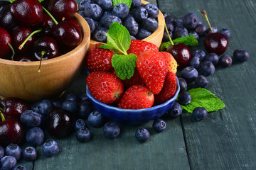 Fresh fruits berries, strawberry, cherries, blueberry on wooden background.
